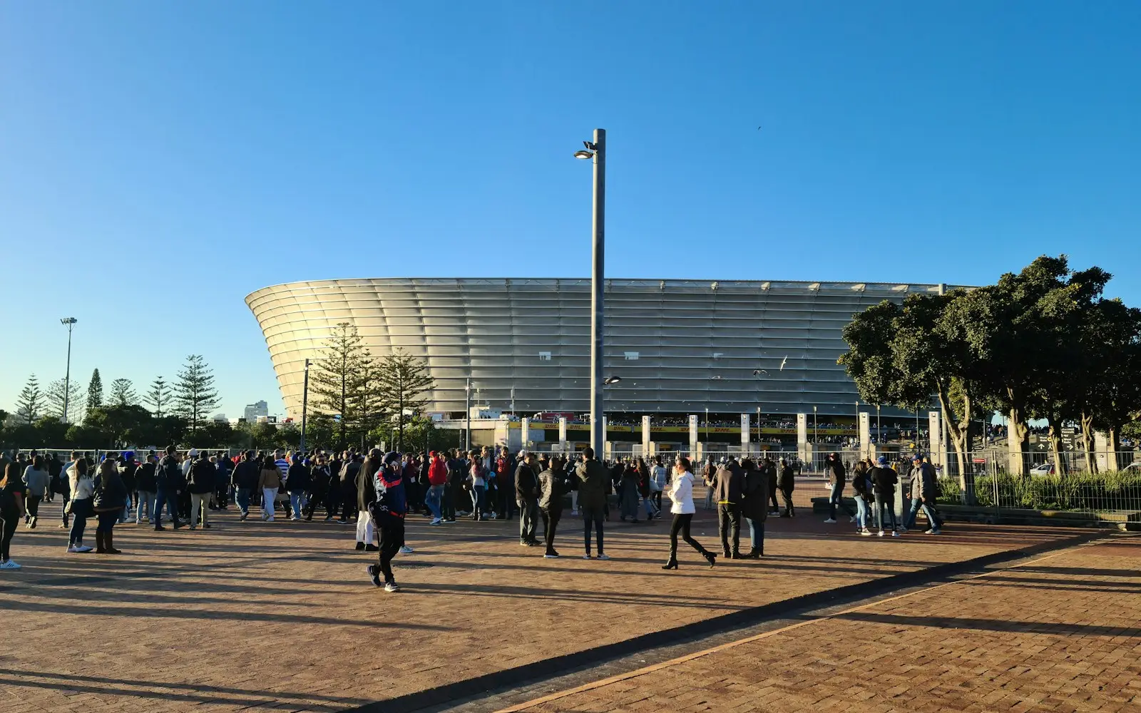 Event crowd gathering on a plaza outside a stadium