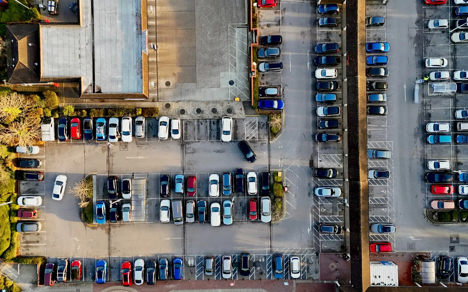 Aerial view of a full parking lot with rows of cars